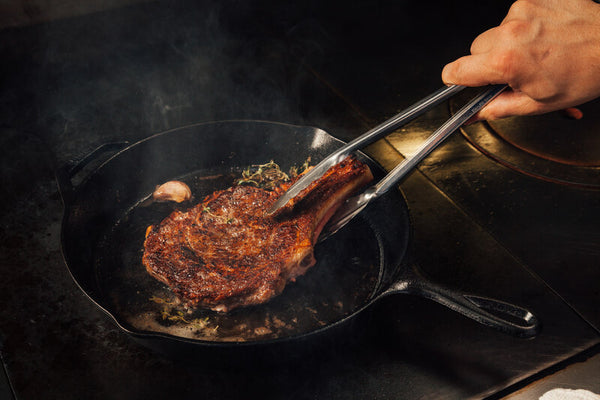 Cooking steak in a cast iron pan.